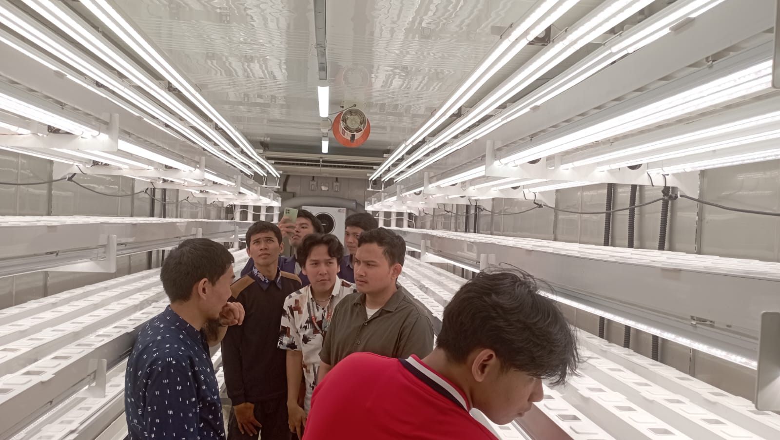 Students working inside the plant factory during a course practicum